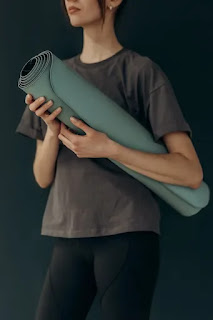 Girl holding yoga mat Yoga mat for doing yoga at hole in the wall