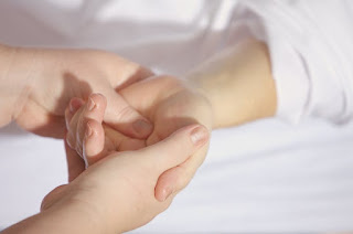 Hand yoga for travel A close-up of hands performing a gentle wrist stretch or neck roll, highlighting in-seat movement.
