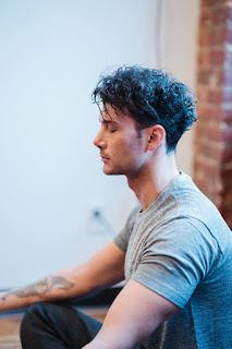 Man with tattoo practices his morning yoga session
