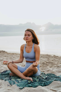Women spending her morning doing yoga on the beach