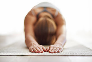 A woman practicing child's pose during a yoga session, promoting deep relaxation and flexibility.