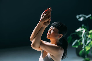 A woman performing eagle pose during a yoga session, promoting balance, breath control, and mental focus. This yoga technique enhances inner peace and body awareness.