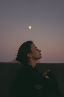 Woman in meditation under the luminous full moon