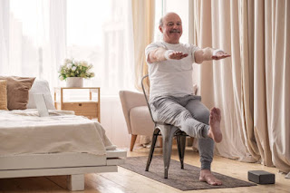 A person performing a Seated Spinal Twist in a chair, aiding spinal mobility and rehabilitation