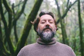 Middle-aged man meditating outdoors to improve cognitive flexibility and mental clarity.