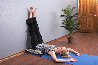 Woman performing Legs Up the Wall Pose to improve circulation and restore cognitive function.