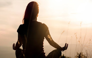 A person sitting comfortably with eyes closed, visualizing their future goals and intentions during meditation