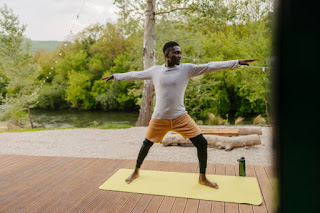 A person in Warrior II pose, standing strong with arms extended, focusing on their intentions