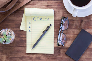 Close-up of journal and pen, representing the reflective process of reconnecting with New Year’s goals.