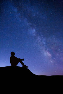 Silhouette of a person looking at a starry sky, symbolizing visualization and dreaming.