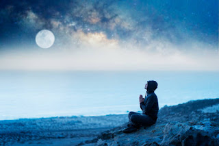 Meditator sitting cross-legged under a glowing full moon, symbolizing release and illumination.