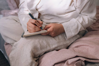 A warm journal setup with a notebook, pen, and a steaming cup of tea on a rustic wooden table, perfect for self-reflection and personal growth.
