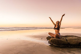 A serene person meditating in a lotus position, focusing on their breath, with a calm, California background.