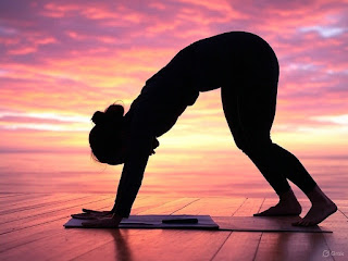 Yogi in Downward Facing Dog at sunrise, unlocking creativity through yoga.