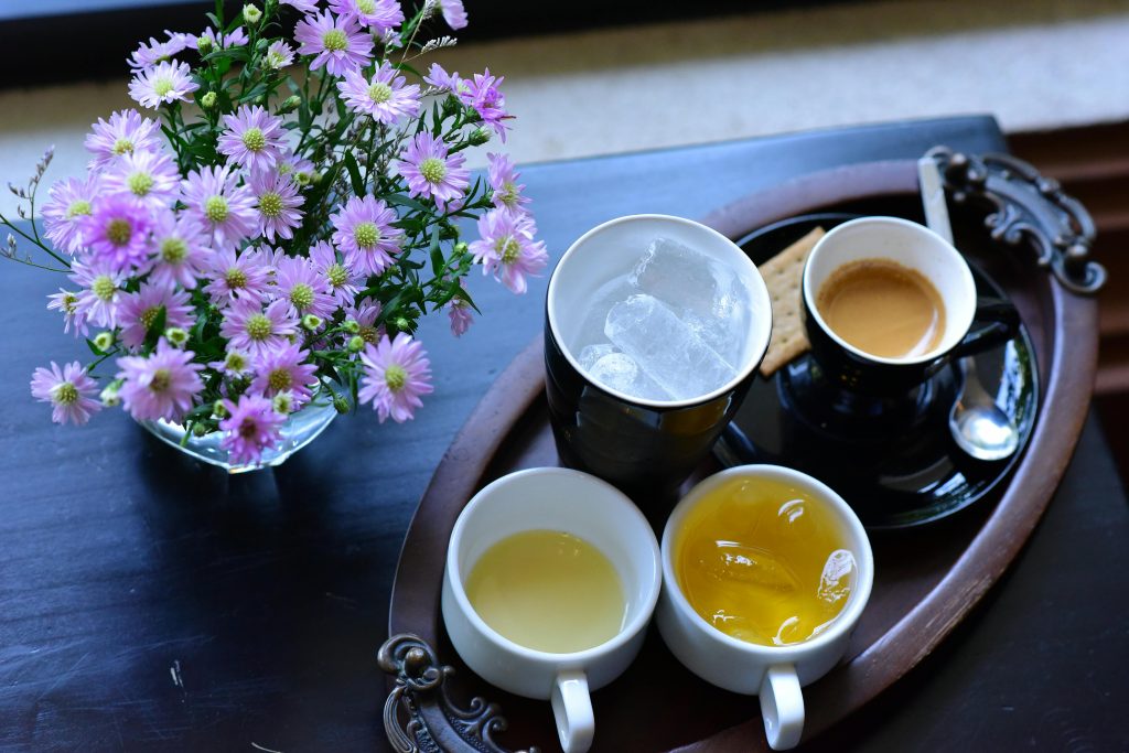 Espresso cup next to chamomile tea, symbolizing the difference between morning activating energy and evening calming energy.