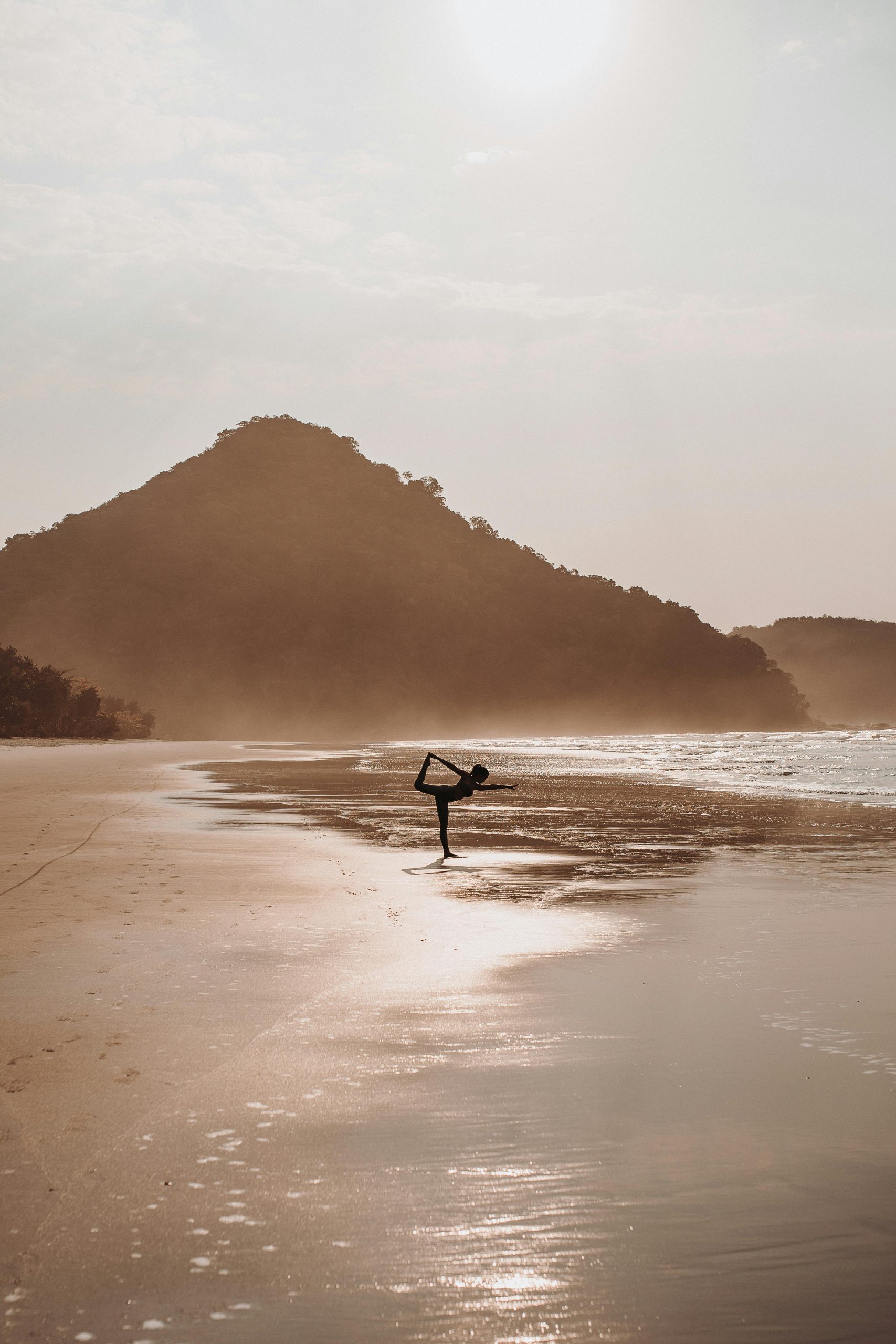 oman practicing yoga on a mat at sunrise, representing mindfulness and habit formation.