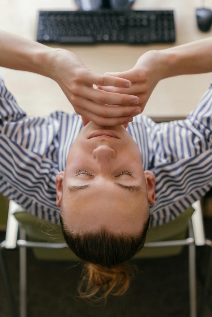 A laptop and coffee cup on a desk, but focus is on relaxed hands resting gently, symbolizing a mindful pause at work.