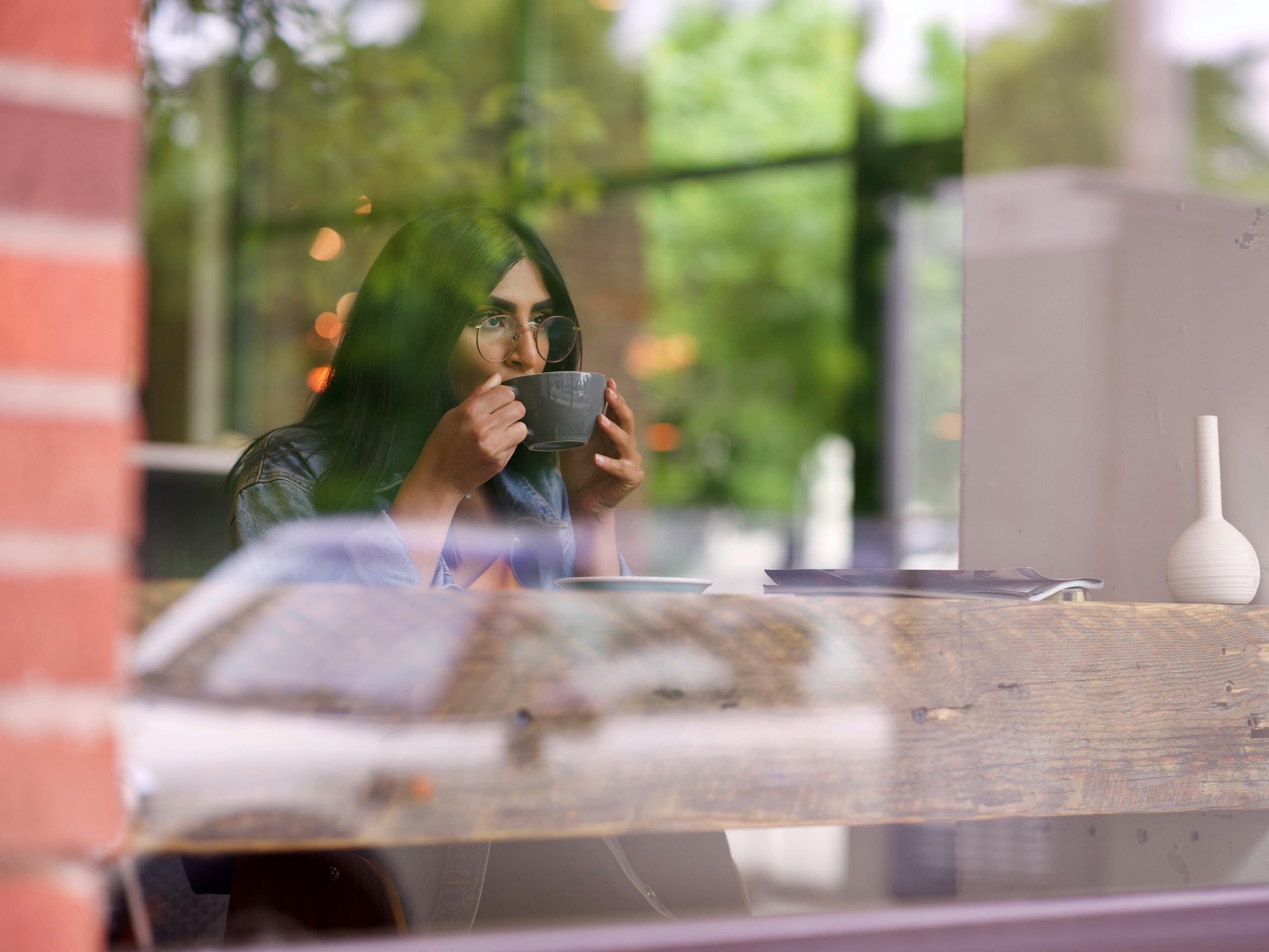 Person practicing a one-minute micro meditation at a desk with coffee, finding stillness during a busy day.