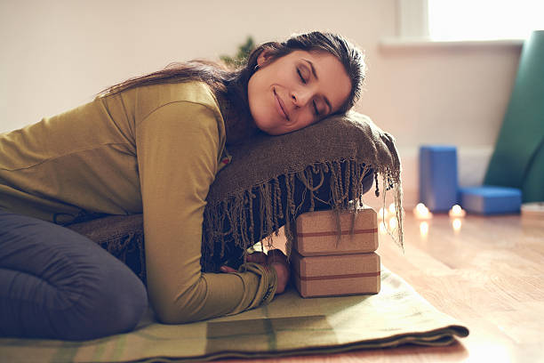 Practitioner in a fully supported Restorative Yoga pose using bolsters and blankets